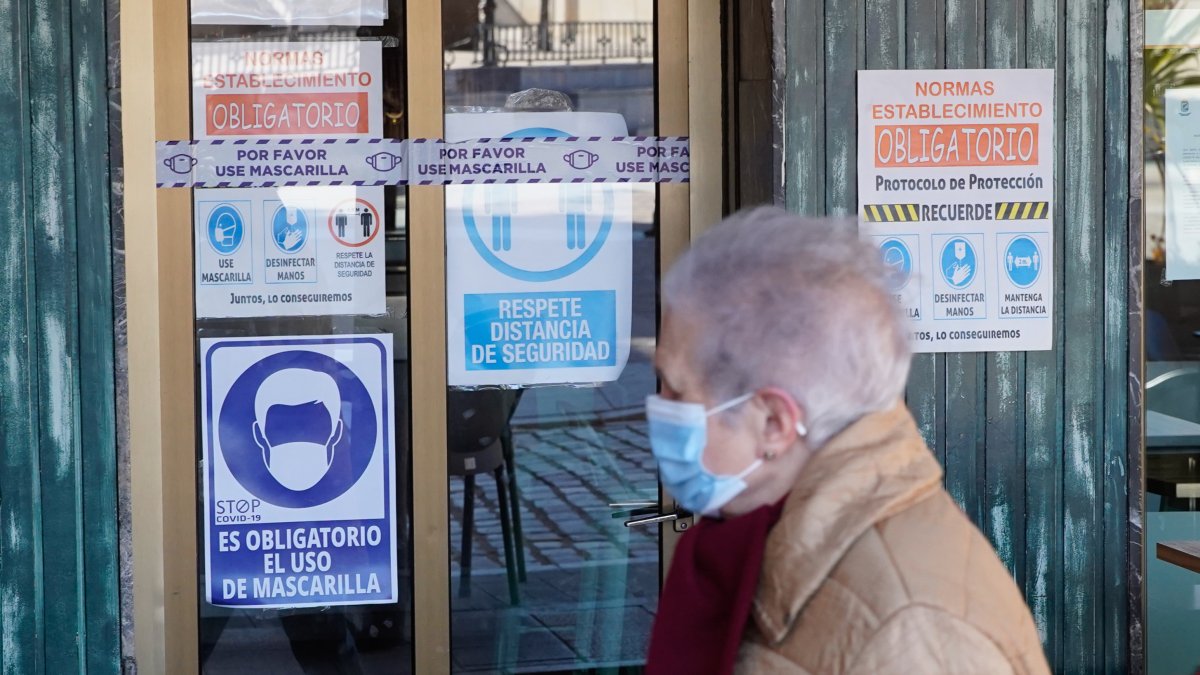 Una mujer pasea delante de un bar en Villalón de Campos. / LOSTAU