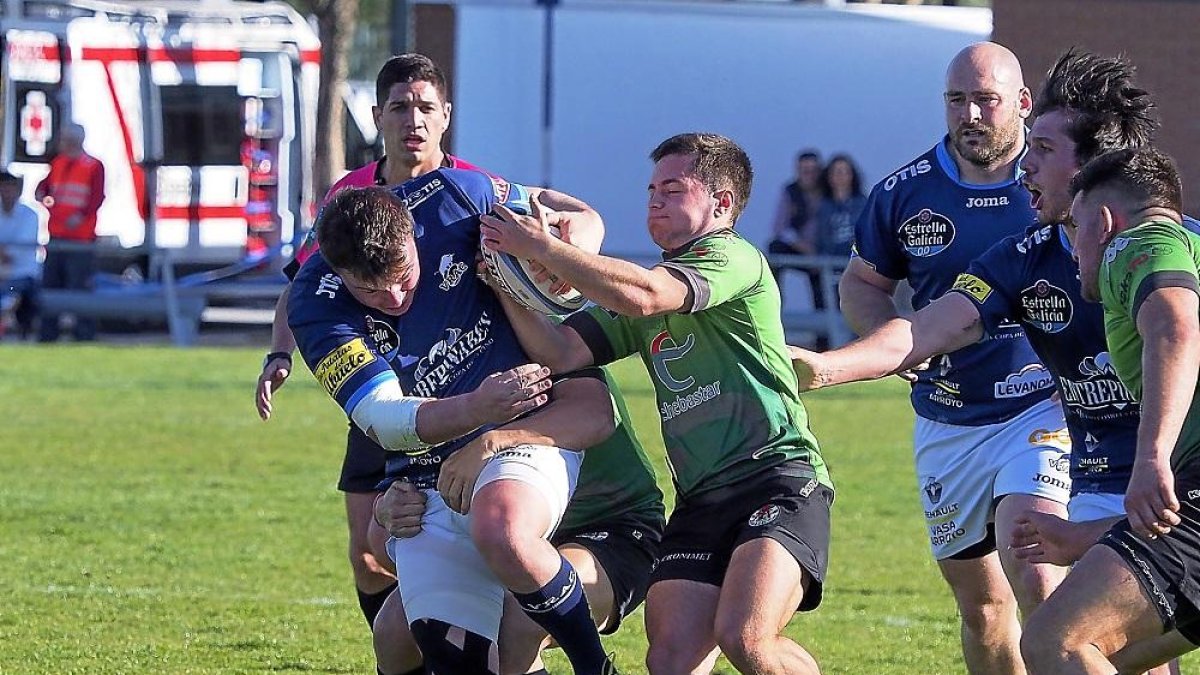 Jokin Escolar intenta arrebatar el oval a Griffiths durante el partido de ayer.-MIGUEL ÁNGEL SANTOS