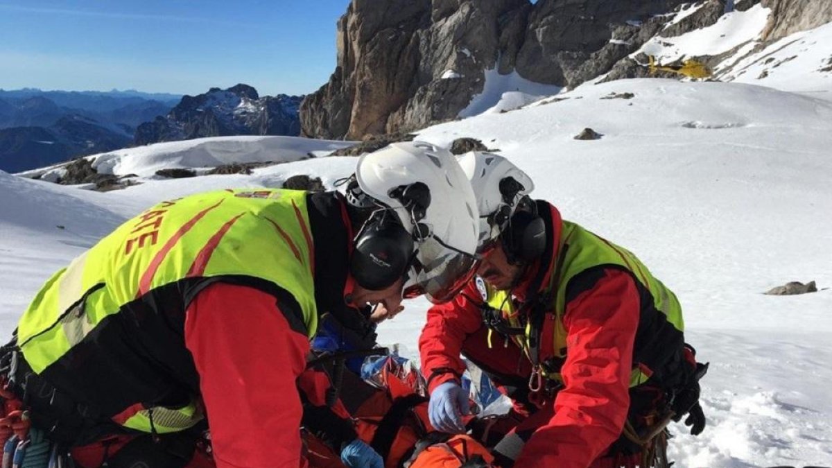 Dos personas de Emergencias rescatando al montañista-EUROPA PRESS