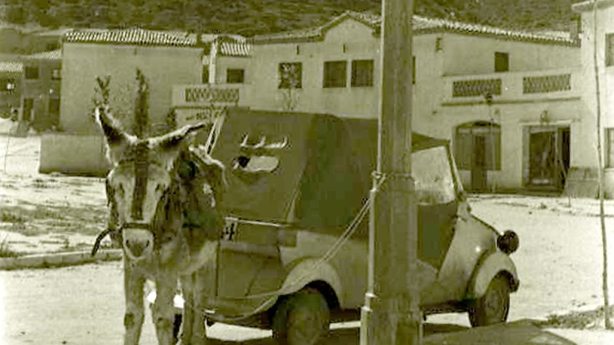 Un pollino junto a un vehículo de la época en el barrio Girón en la década de los 60. ARCHIVO MUNICIPAL