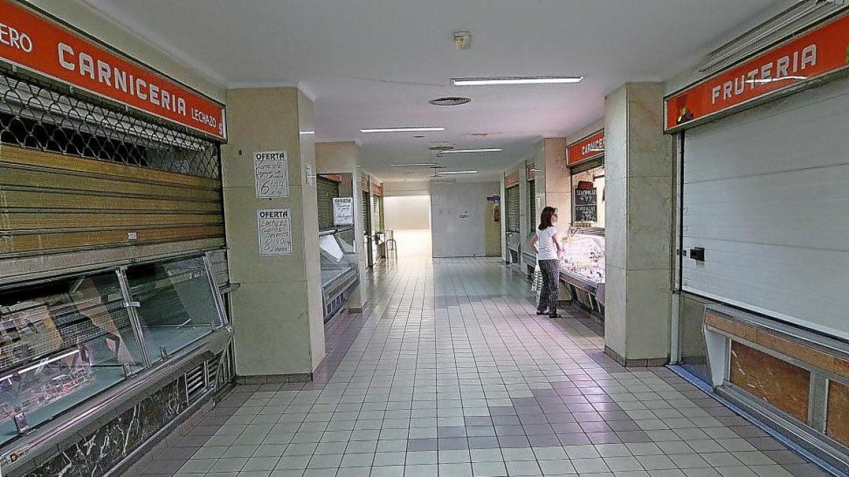 Una cliente en el único puesto de carnicería que estaba ayer abierto en el mercado municipal de López Gómez.-J. M. LOSTAU