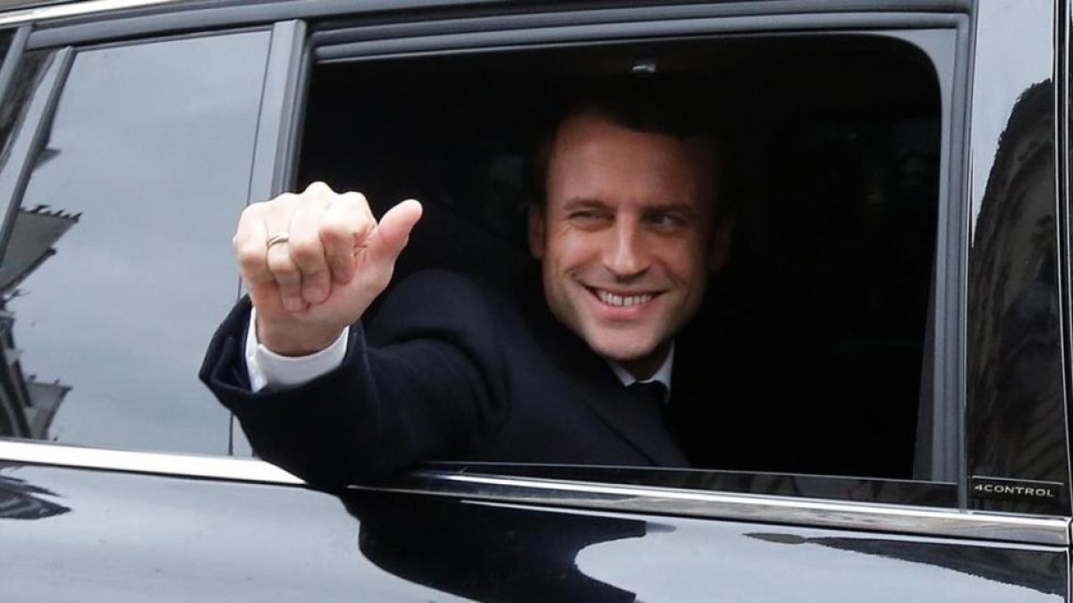 Emmanuel Macron, saluda feliz desde el coches el día de la segunda vuelta de las presidenciales.-REUTERS