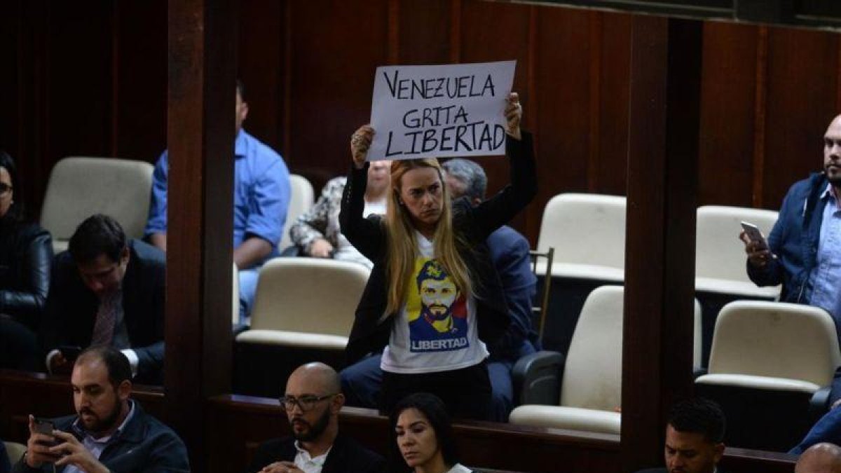 La activista Lilian Tintori, esposa del arrestado opositor venezolano Leopoldo López, muestra una pancarta contra Maduro en la Asamblea Nacional de Venezuela.-FEDERICO PARRA (AFP)