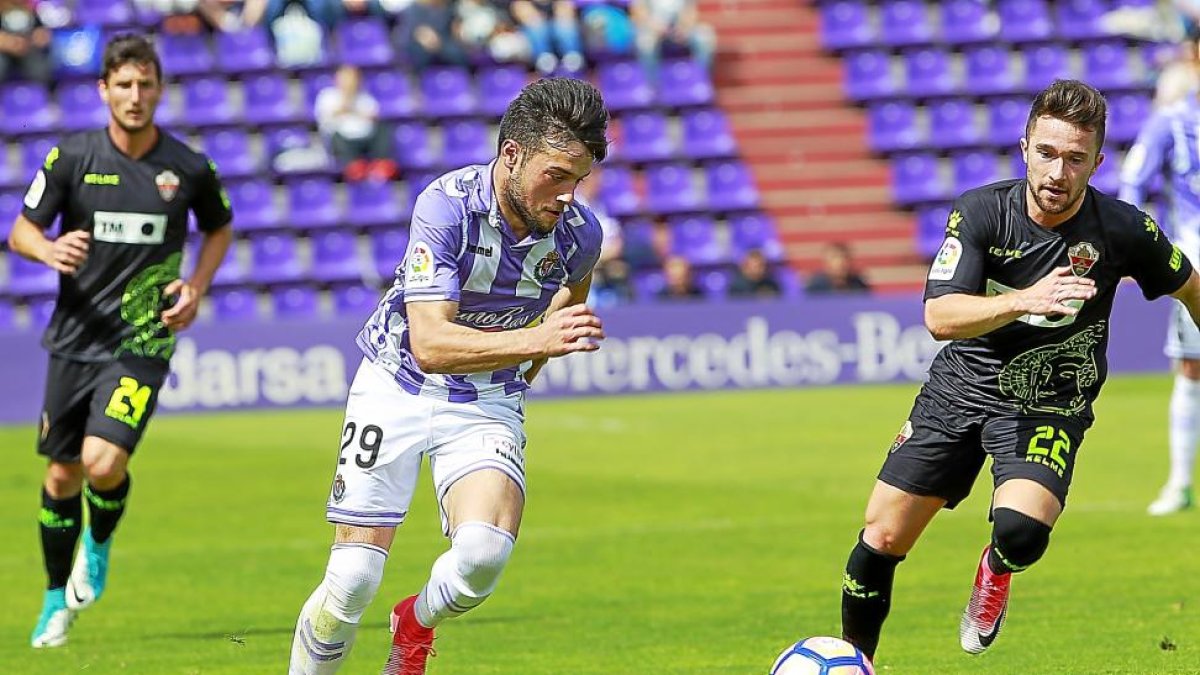Jose corre tras el balón ante la presencia de Iriondo en el partido frente al Elche.-J.M.LOSTAU
