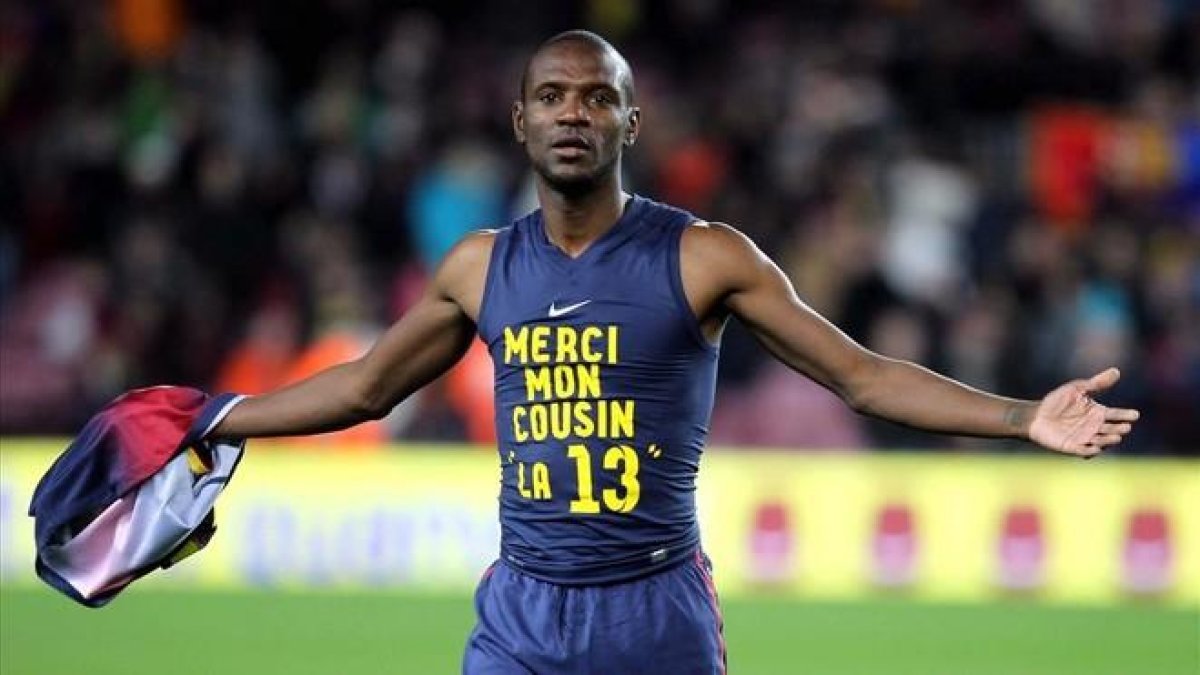 El defensa francés del FC Barcelona Eric Abidal muestra una camiseta de agradecimiento a su primo, donante de su trasplante, durante un partido en 2013.-TONI ALBIR