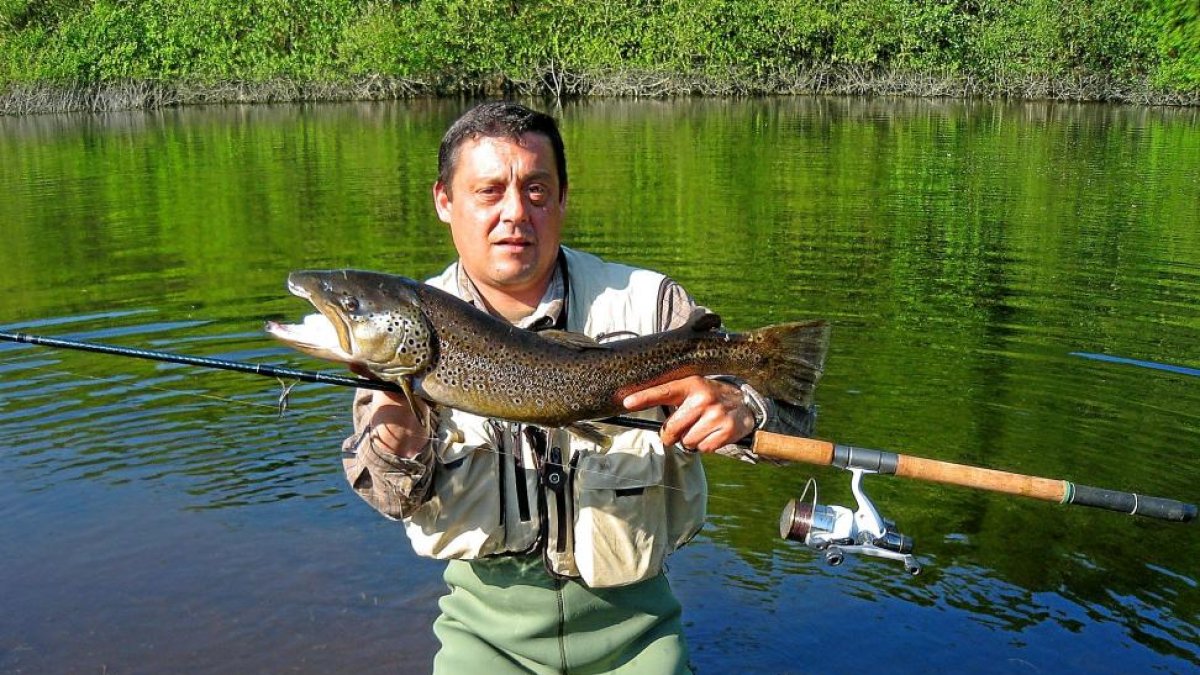 Pescador con un soberbio ejemplar de trucha capturado en Salamanca.-L. FUENTE