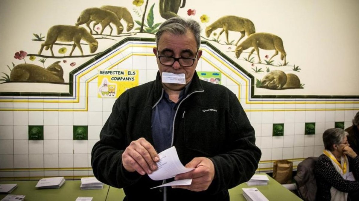 Hombre recoge una papeleta el 21-N-JOAN PUIG