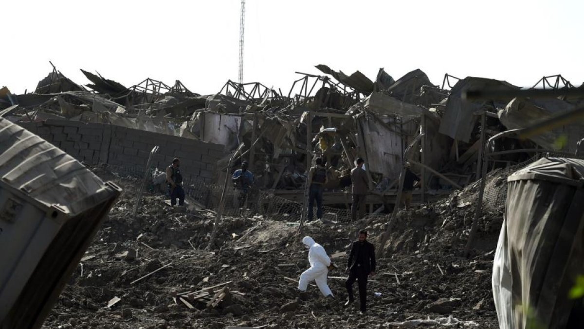 Agentes de las fuerzas de seguridad afganas inspeccionan la zona del atentado, en las afueras de Kabul.-AFP / WAKIL KOHSAR