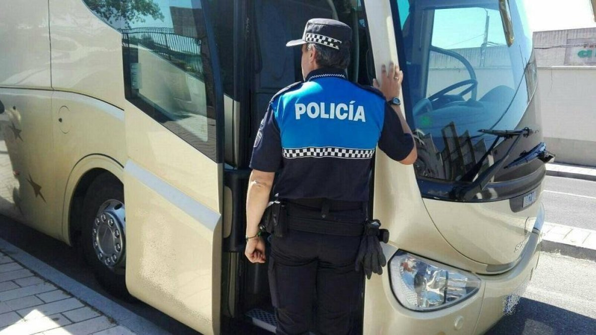 Un agente se dispone a hacer el seguimiento a un vehículo de transporte escolar.-POLICIA MUNICIPAL