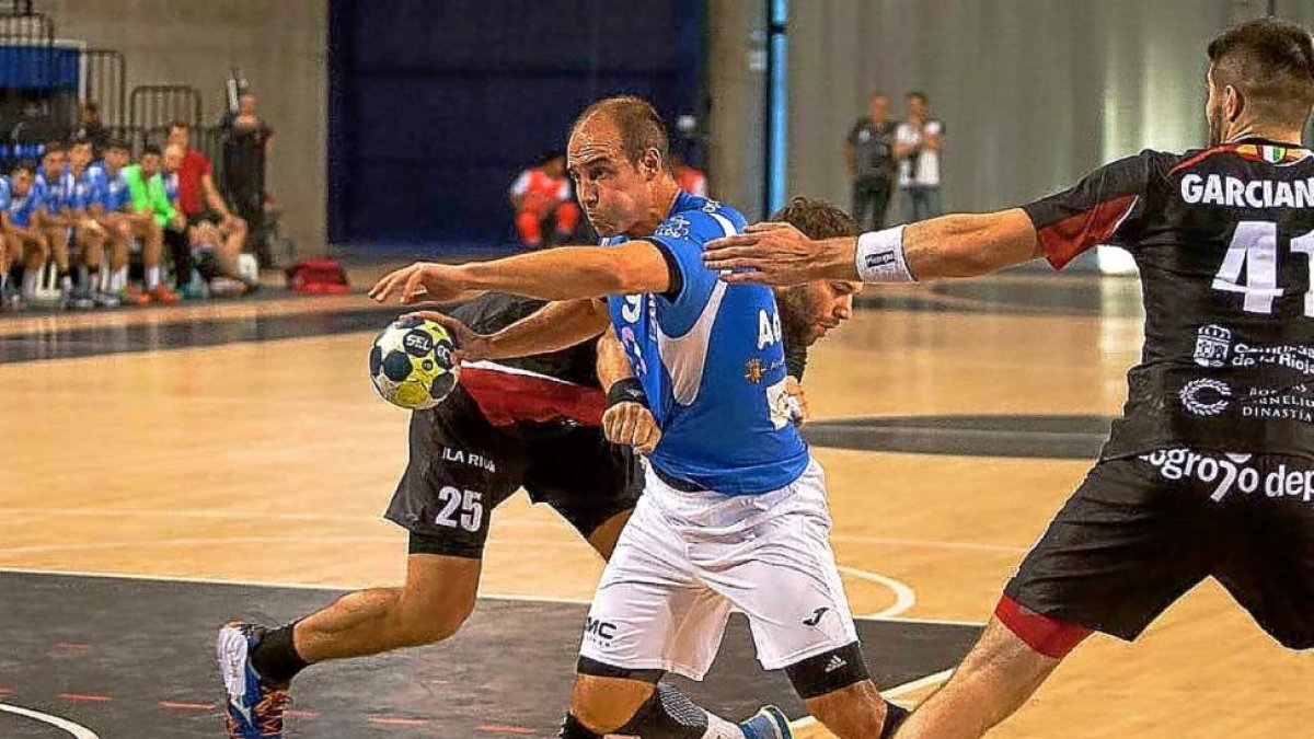 Adrián Fernández intenta salvar la defensa del BM La Rioja en el partido disputado ayer en el Palacio de Deportes de Logroño.-PHOTO-DEPORTE