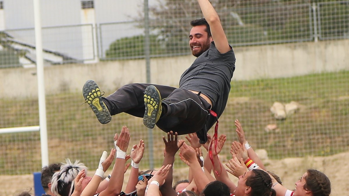 Las jugadoras del Crealia mantean a su entrenador Freddie Roberti tras lograr el ascenso en Las Rozas. / DOMINGO TORRES