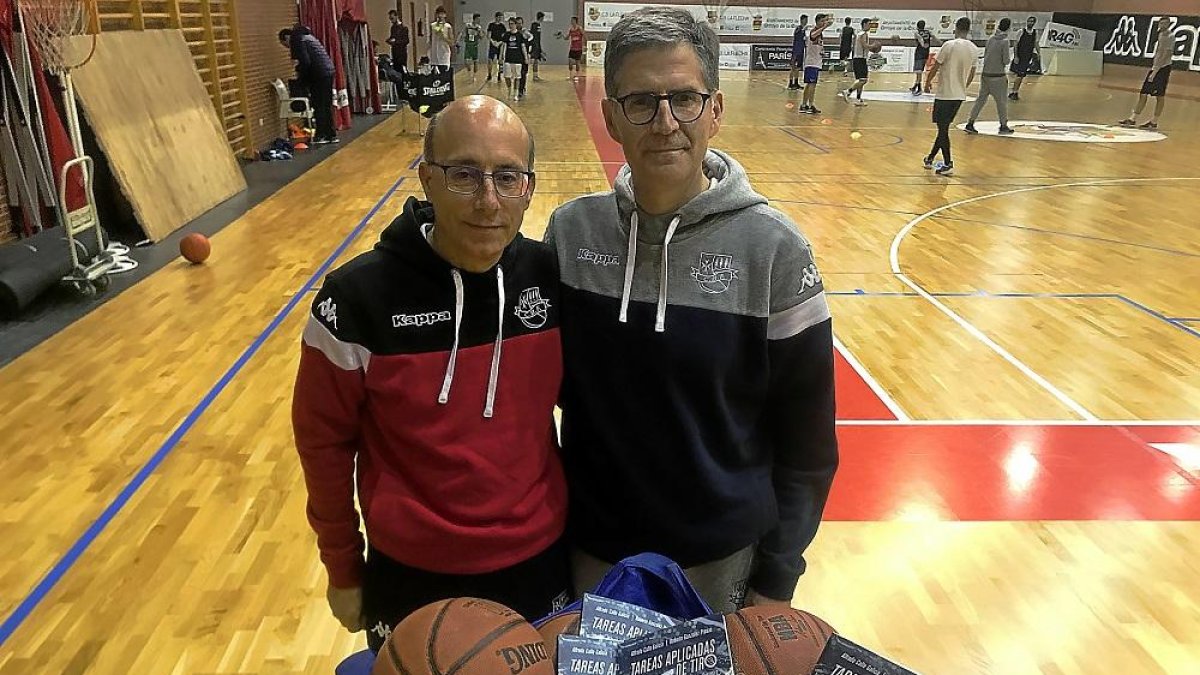 Alfredo Calle y Roberto González posan con su libro y un carro de balones en el polideportivo La Vega antes.-G. VELASCO