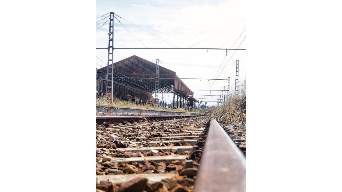 Viejo trazado de vía, con la antigua estación leonesa al fondo.-El Mundo
