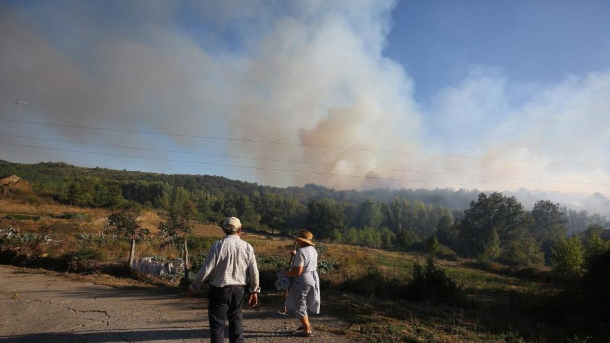 Dos personas observan la cortina de humo que se levantó durante la jornada de ayer.-ICAL