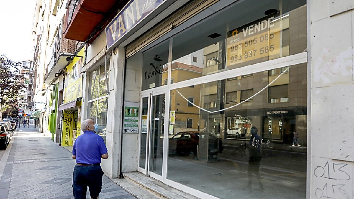 Un transeúnte lee el cartel de ‘se vende’ en el escaparate de un local vacío de la calle Labradores. J.M. LOSTAU