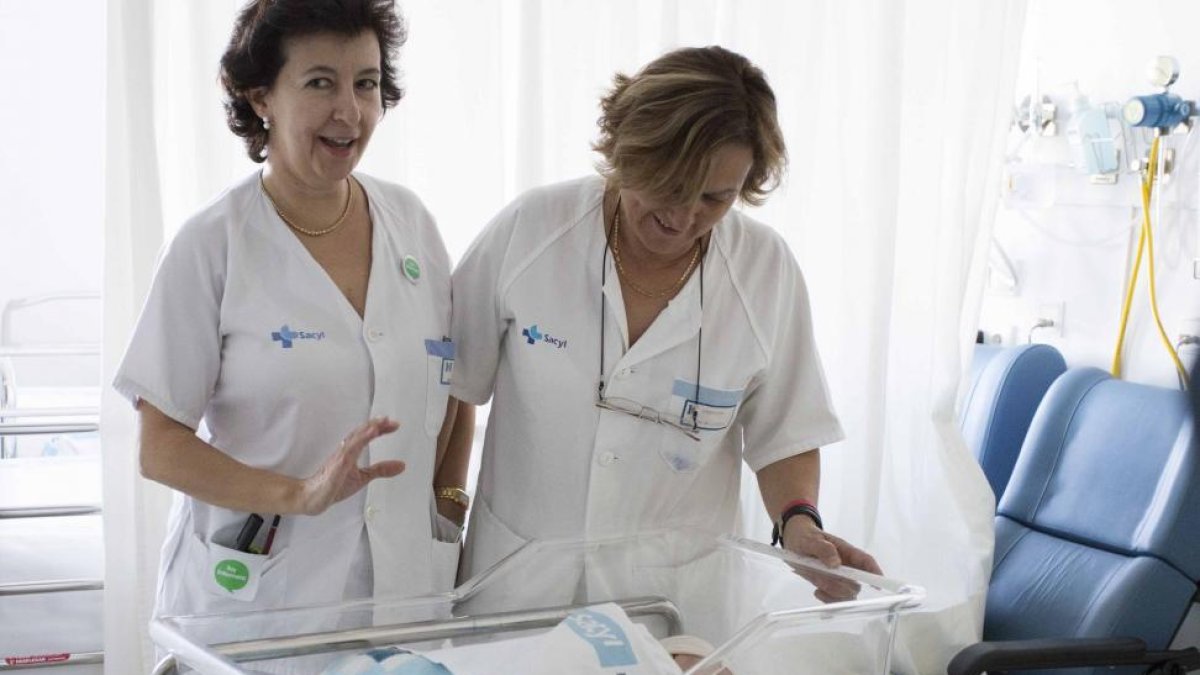 Dos trabajadoras del Sacyl posan con el primer niño nacido en Ávila en 2017.-ICAL