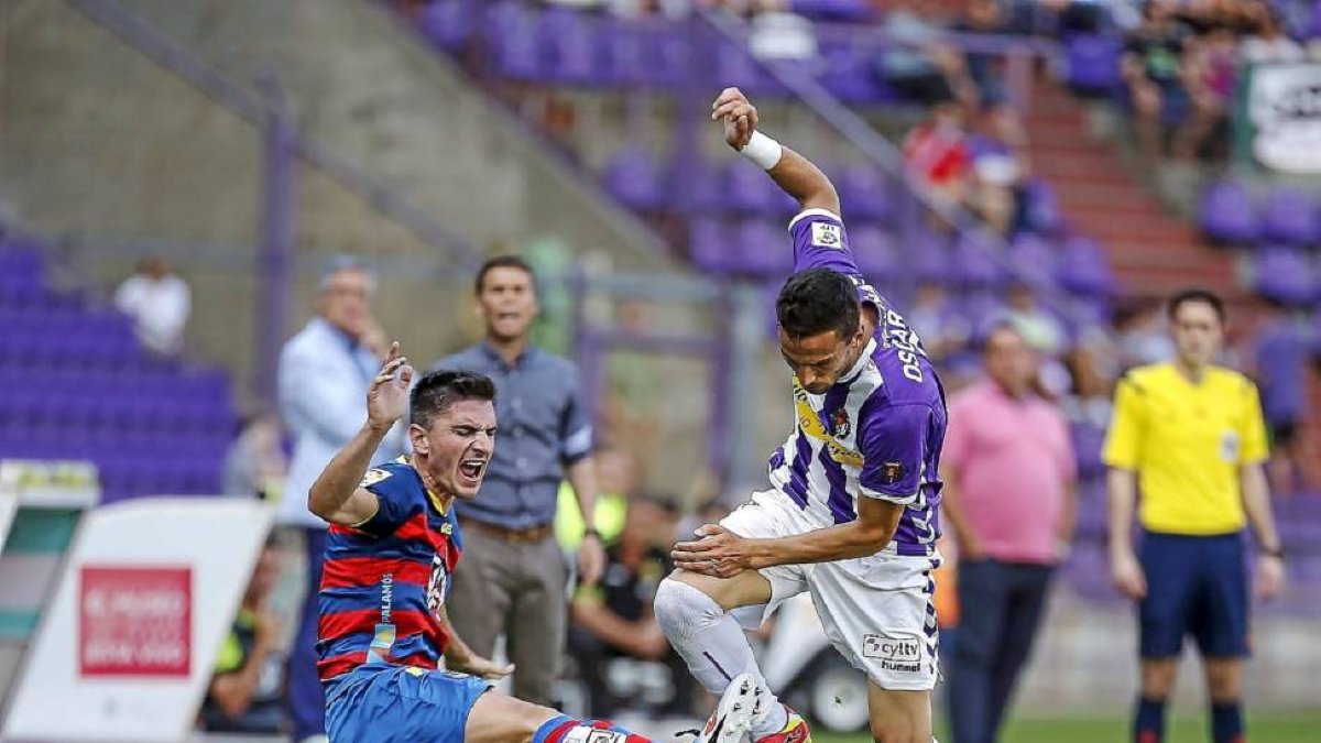 Óscar Díaz se intenta ir del marcaje del jugador de la UE Llagostera.-M.Á. Santos