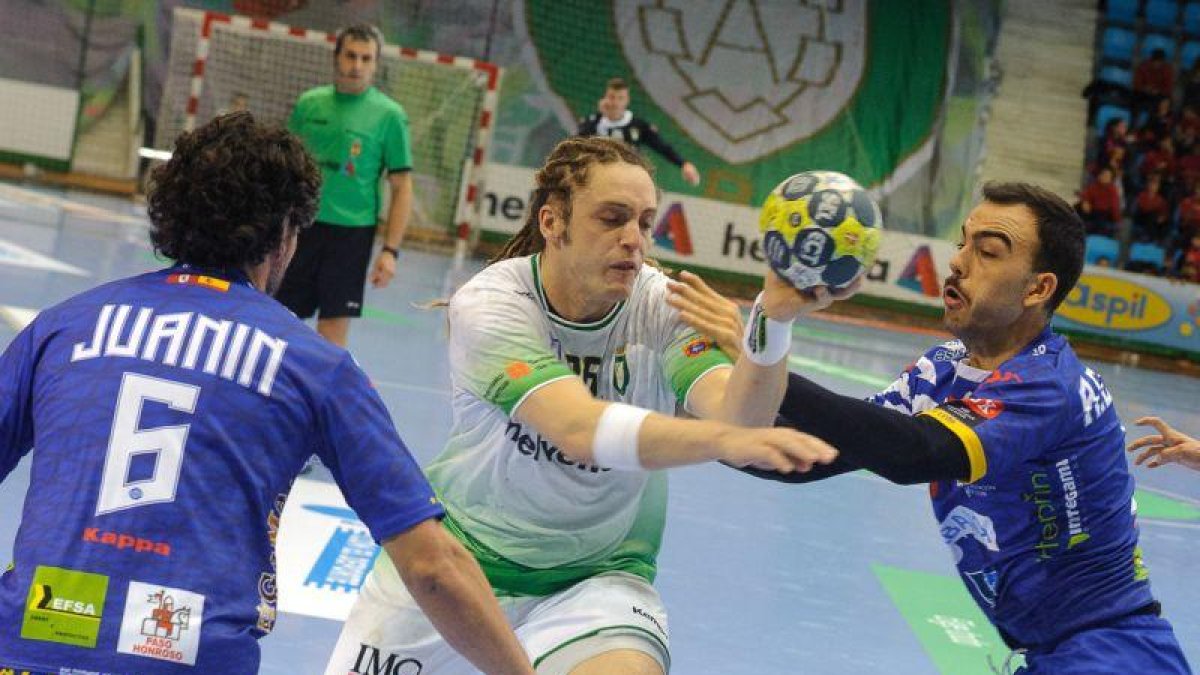 Oswaldo Dos Santos del Anaitasuna entre dos jugadores rivales.-HELVEITIA ANAITASUNA