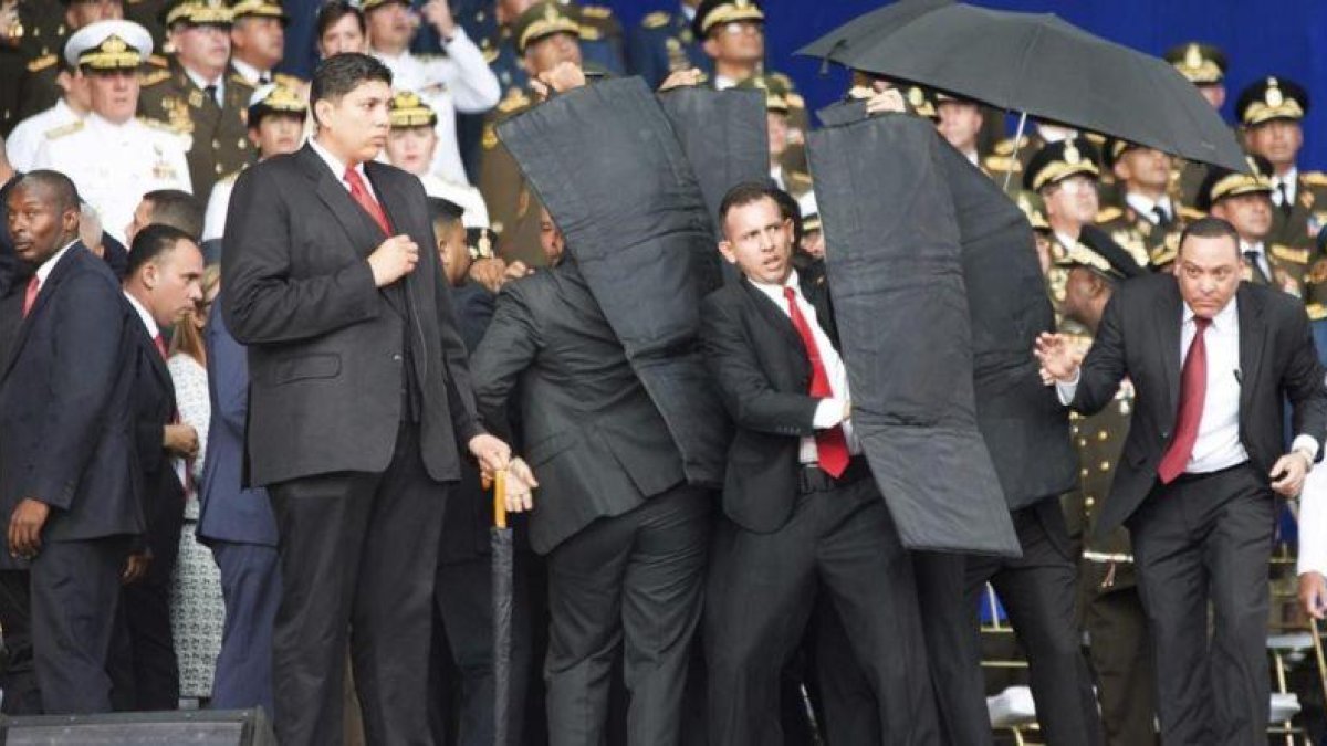 Personal de seguridad protege a Nicolás Maduro tras el atentado con drones en Venezuela.-AP / XINHUA