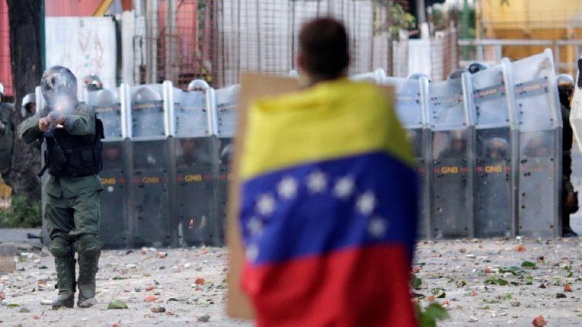 Un hombre con la bandera venezolana en la capital, Caracas.-UESLEI MARCELINO (REUTERS)