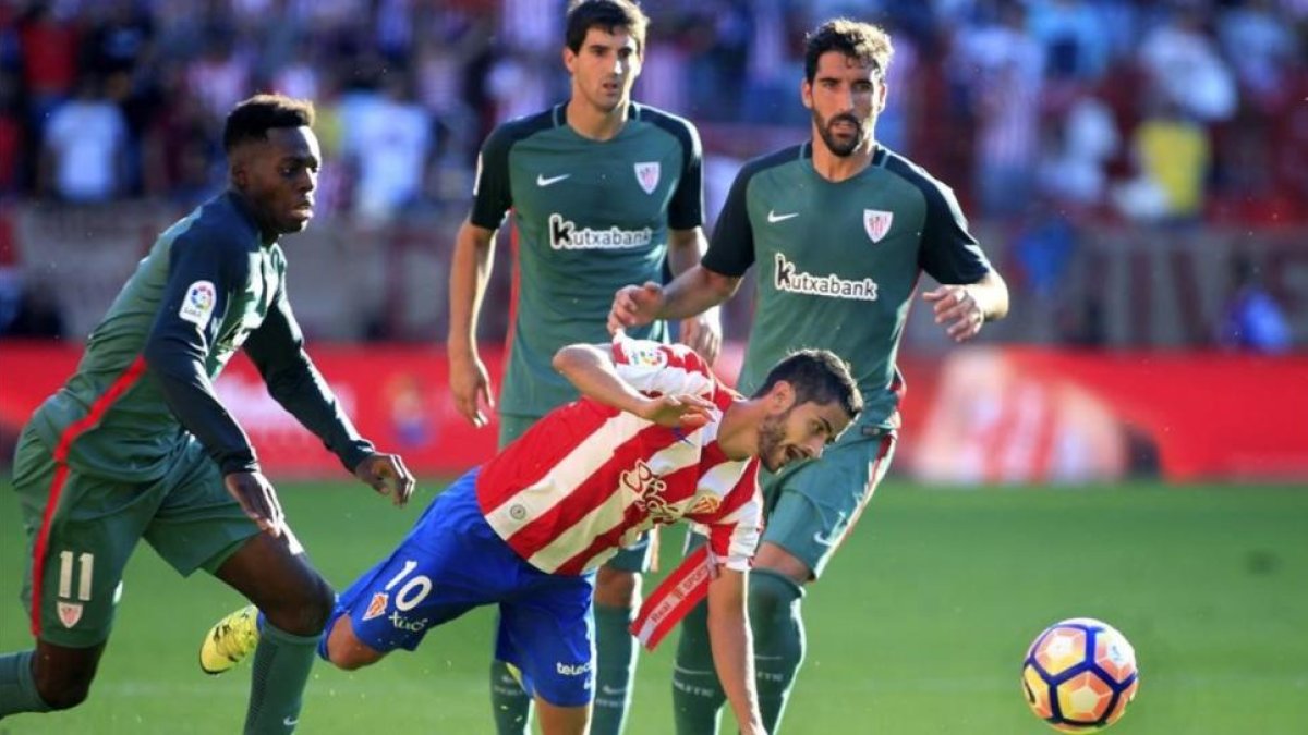 Iñaki Williams pugna con Nacho Cases en una jugada del partido de El Molinón.-EFE / ALBERTO MORANTE