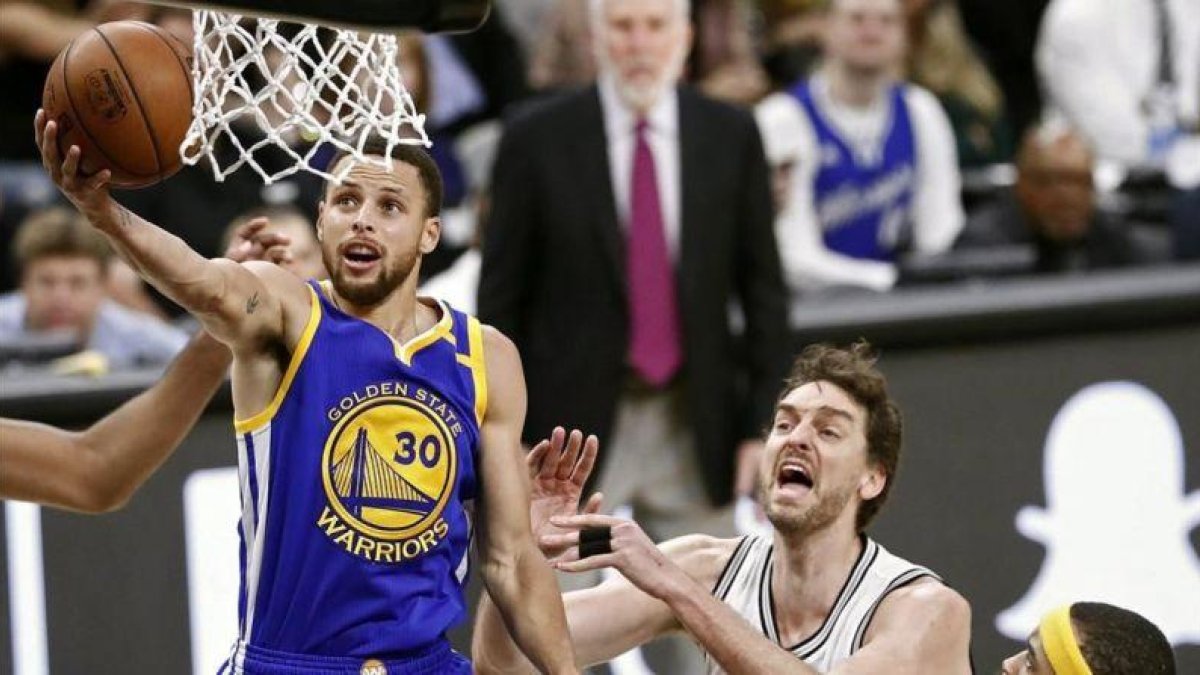 Pau Gasol (San Antonio) y Stephen Curry (Golden State) en la victoria de los Warriors.-EFE / LARRY W SMITH
