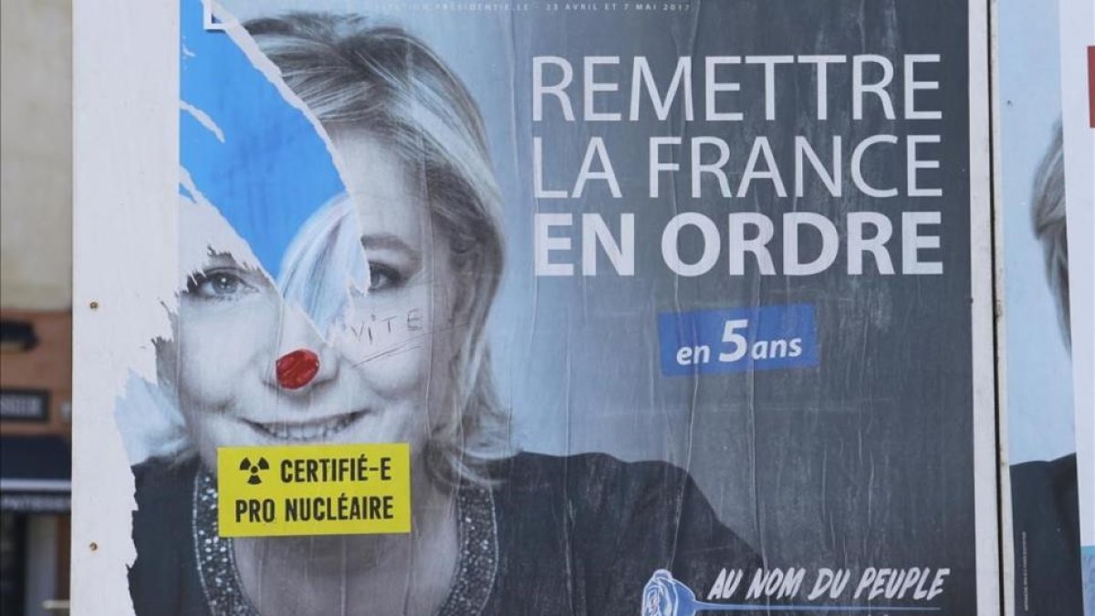 Un cartel electoral de Marine Le Pen en Marsella en el que alguién ha añadido un adhesivo en el que se lee