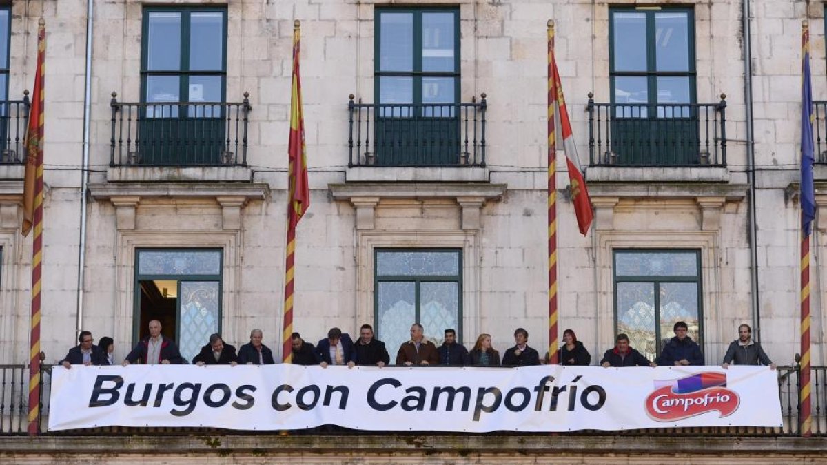 El alcalde de Burgos, Javier Lacalle, y los portavoces de los grupos municipales colocan una pancarta en el balcón del Ayuntamiento de apoyo a la reapertura de la nueva Campofrío, con motivo del segundo aniversario del incendio.-ICAL
