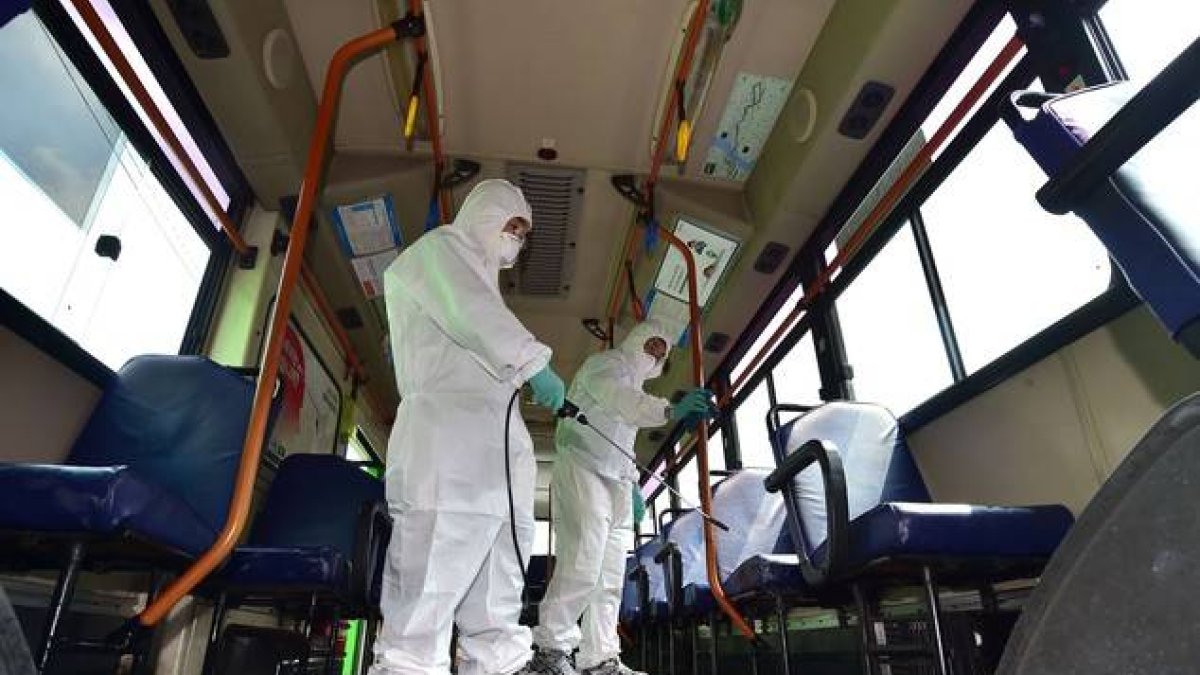 Sanitarios surcoreanos desinfectan un autobús ante la amenaza del virus MERS.-Foto: AFP / JUNG YEON-JE