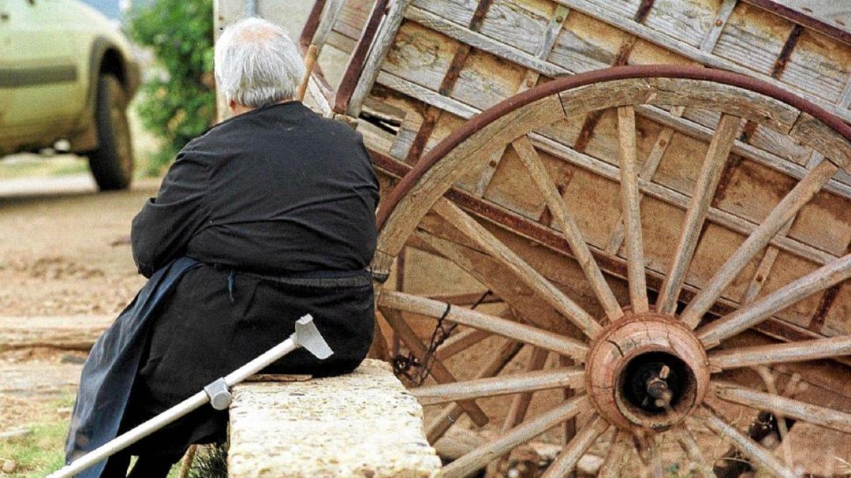 Una anciana descansa junto a un carro.-EL MUNDO