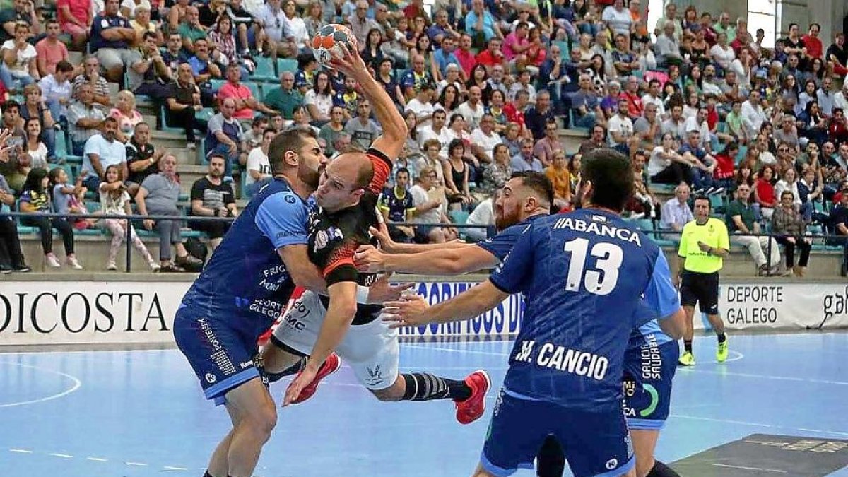 Adrián Fernández se lanza contra los jugadores de Cangas para intentar lanzar a portería.-PHOTO-DEPORTE