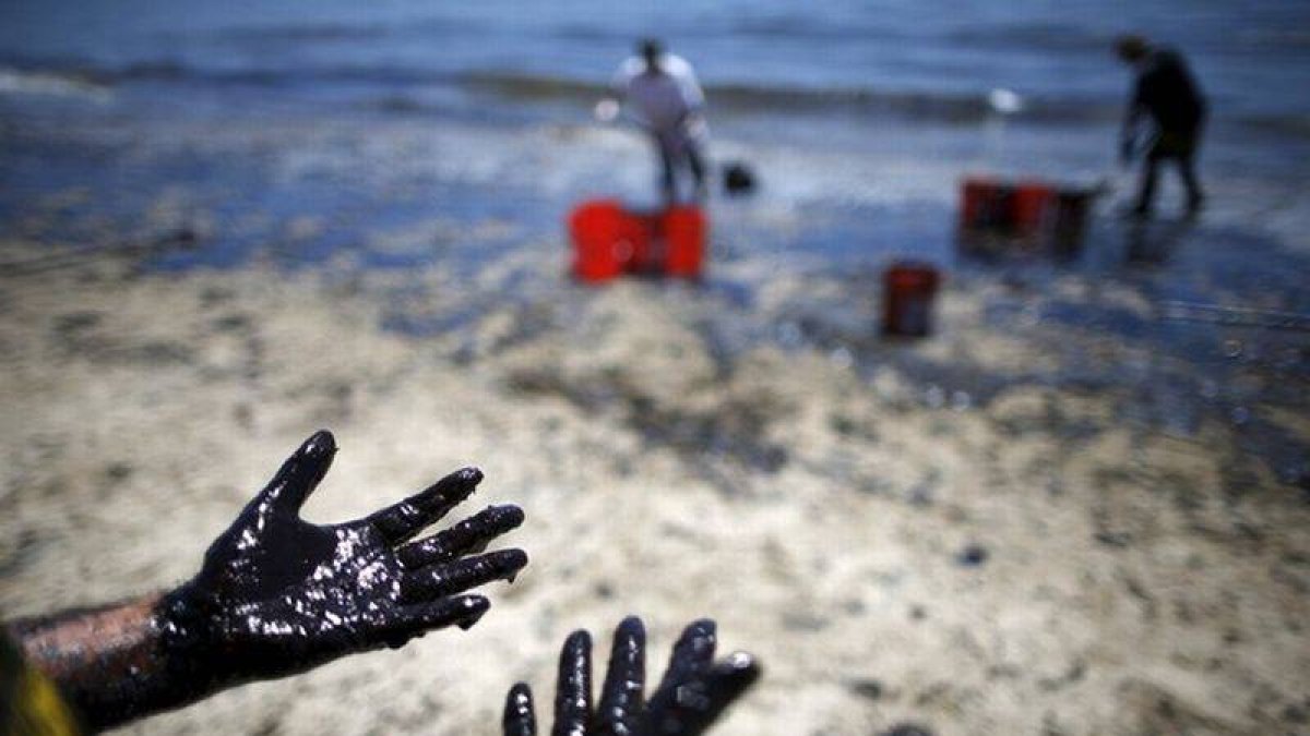 Voluntarios cargan cubos de petróleo de las costas de Santa Bárbara.-Foto: REUTERS / LUCY NICHOLSON