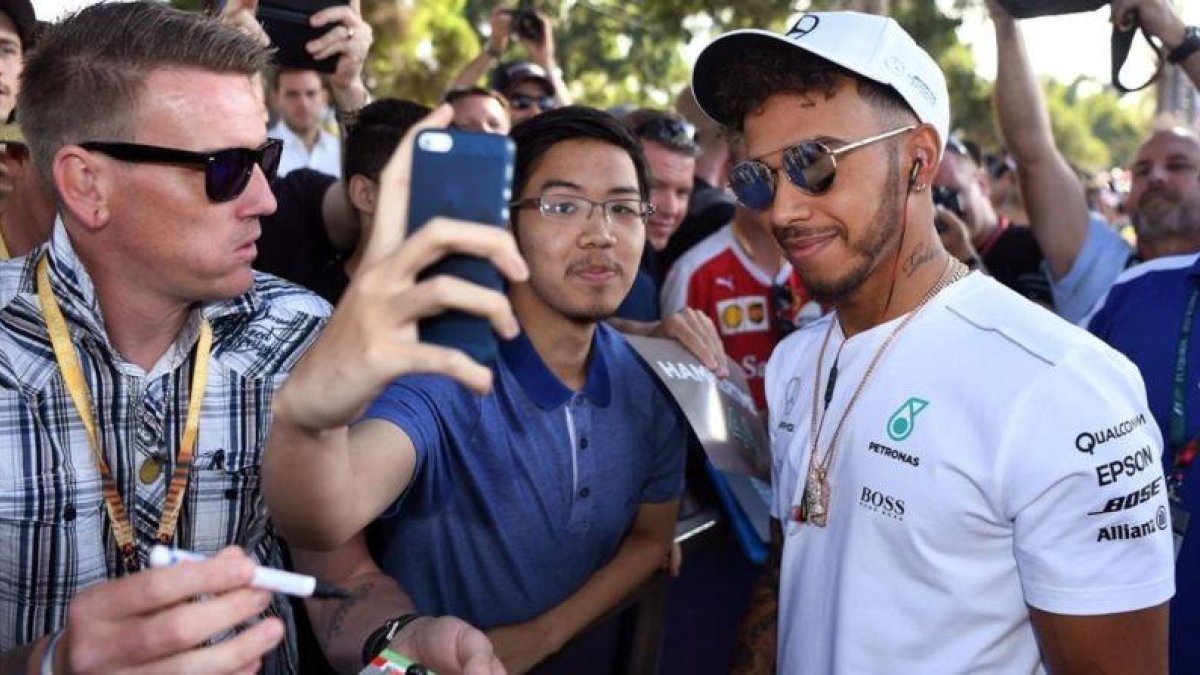 Lewis Hamilton se hace fotos con aficionados en Melbourne.-AFP / WILLIAM WEST