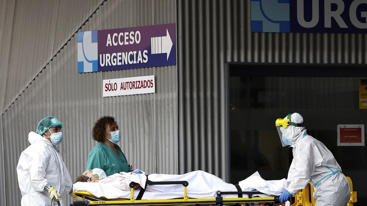 El personal sanitario atiende la llegada de un paciente en la entrada del hospital Clínico. J.M. LOSTAU