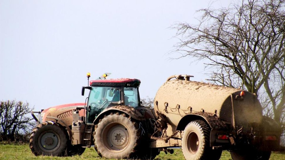 Un  trabajador esparce purines con cisterna en el campo.-ASAJA