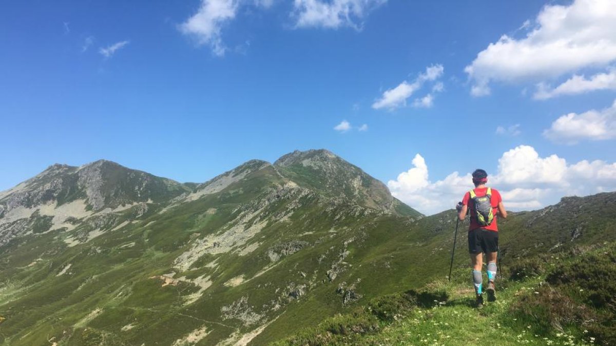 Un montañero transita por el cordal con las cumbres del Cebolleda y Gildar al fondo.-N.S.