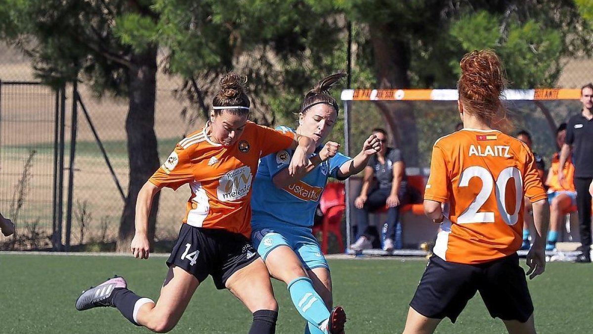 Nata intenta eludir el marcaje de la jugadora de Osasuna.-MIGUEL ÁNGEL SANTOS