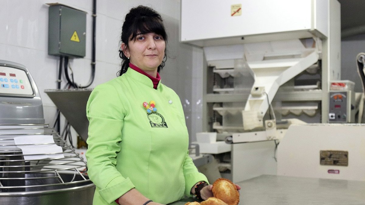 Ana de Castro dirige el obrador junto a Raúl. En la imagen, muestra los rebojos recién salidos del horno. El dulce, dicen, tiene la misma fórmula que la magdalena pero sin grasa. / J.L.C.
