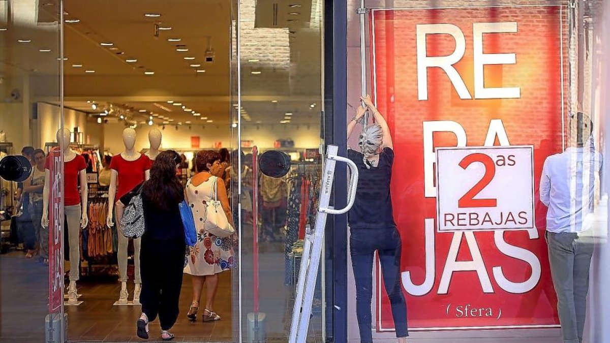 Imagen de un escaparate con carteles de descuentos  durante la campaña de rebajas de verano.-ICAL