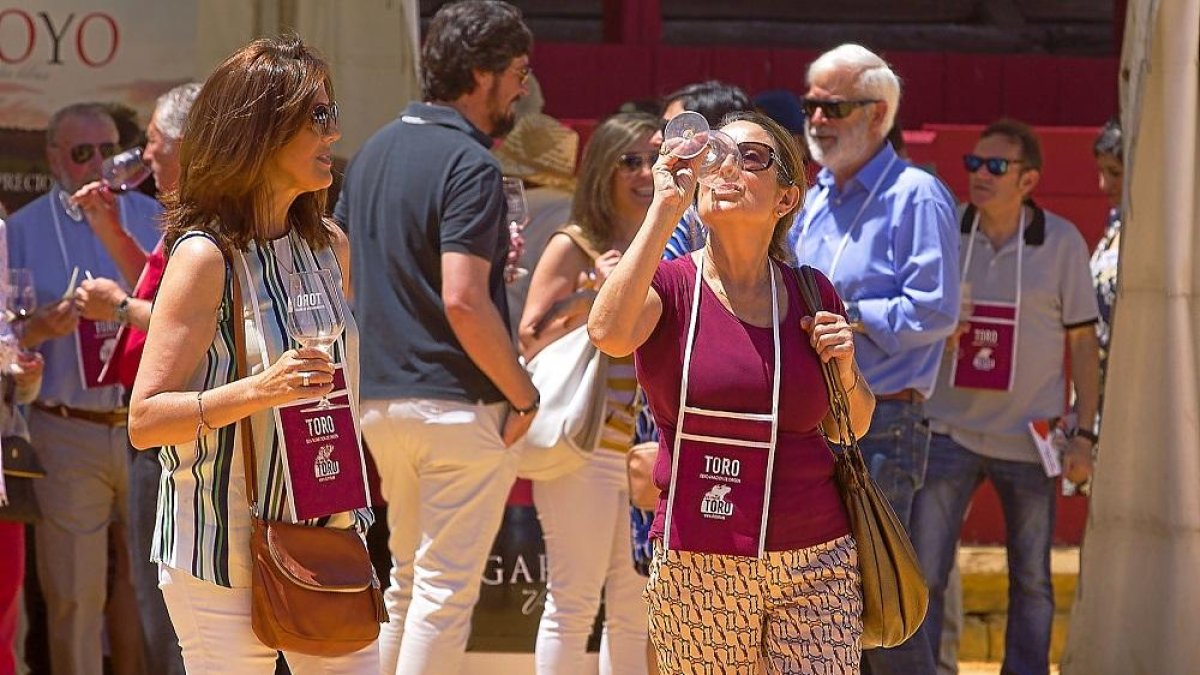 Dos mujeres disfrutan de una copa de vino en la Feria del Vino de Toro.-ICAL