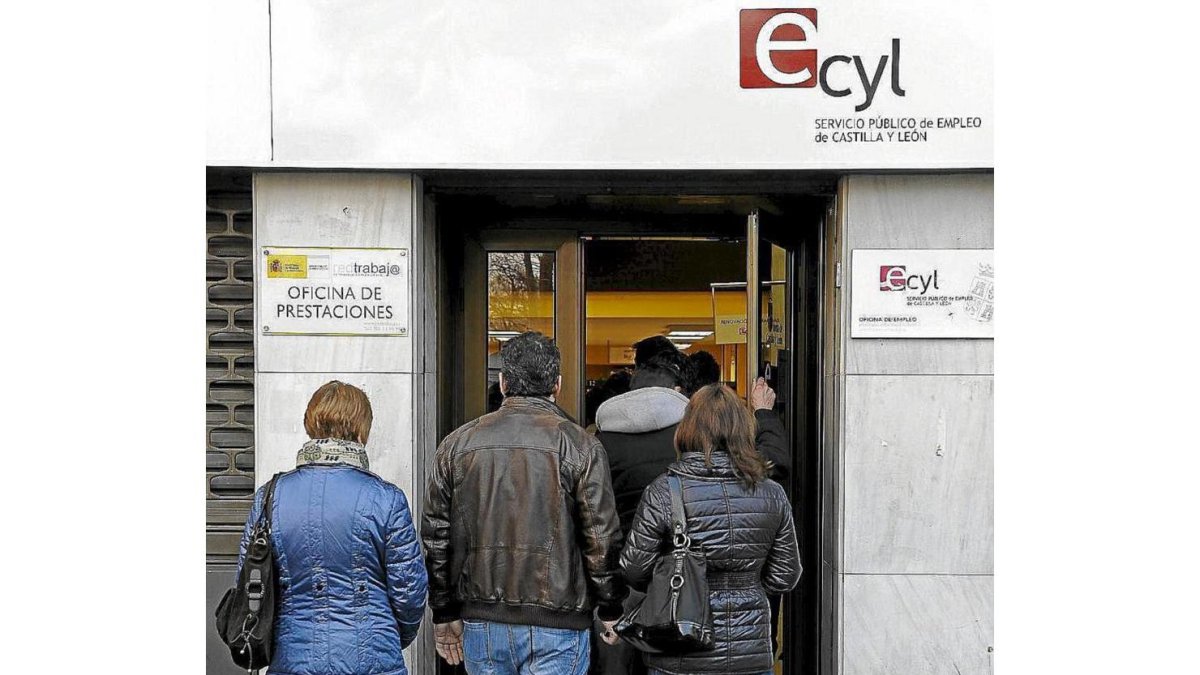 Tres personas esperan a entrar en una oficina de trabajo en Valladolid.-EL MUNDO