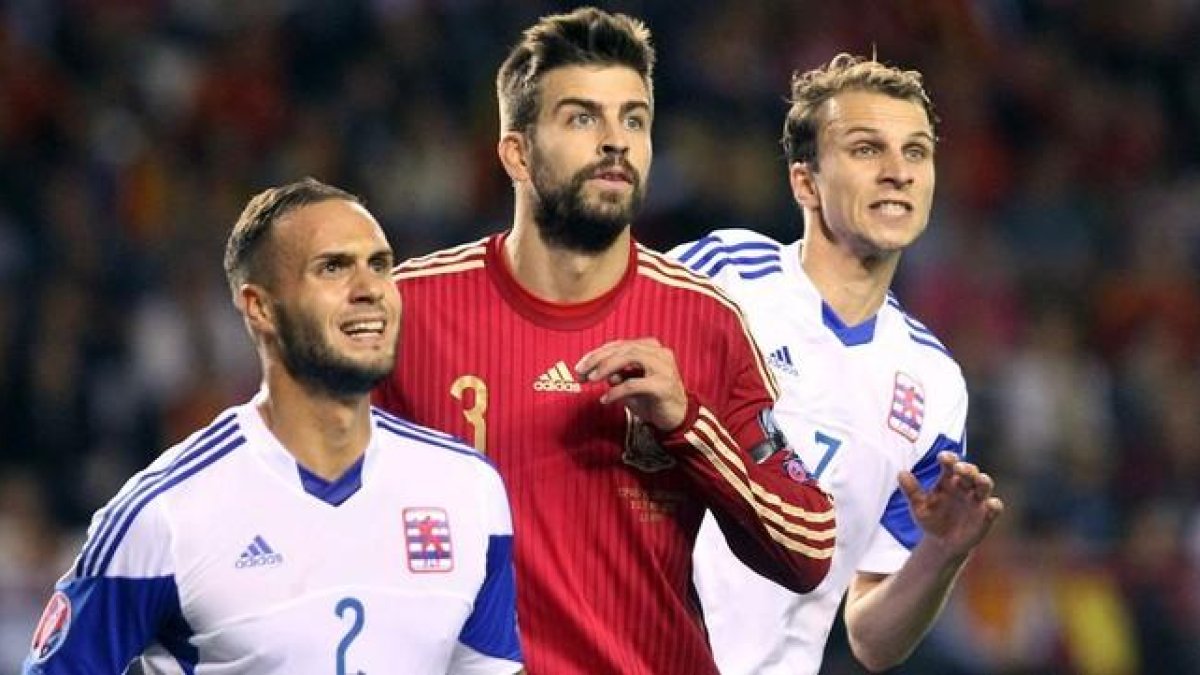Piqué, entre dos jugadores de Luxemburgo, en el partido jugado en Logroño el 9 de octubre.-EFE / RAQUEL MANZANARES