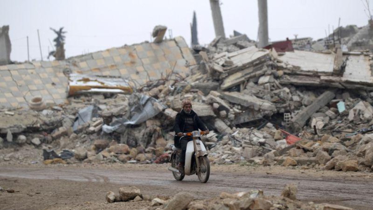 Un hombre circula en moto por los alrededores de Alepo.-KHALIL ASHAWI / REUTERS