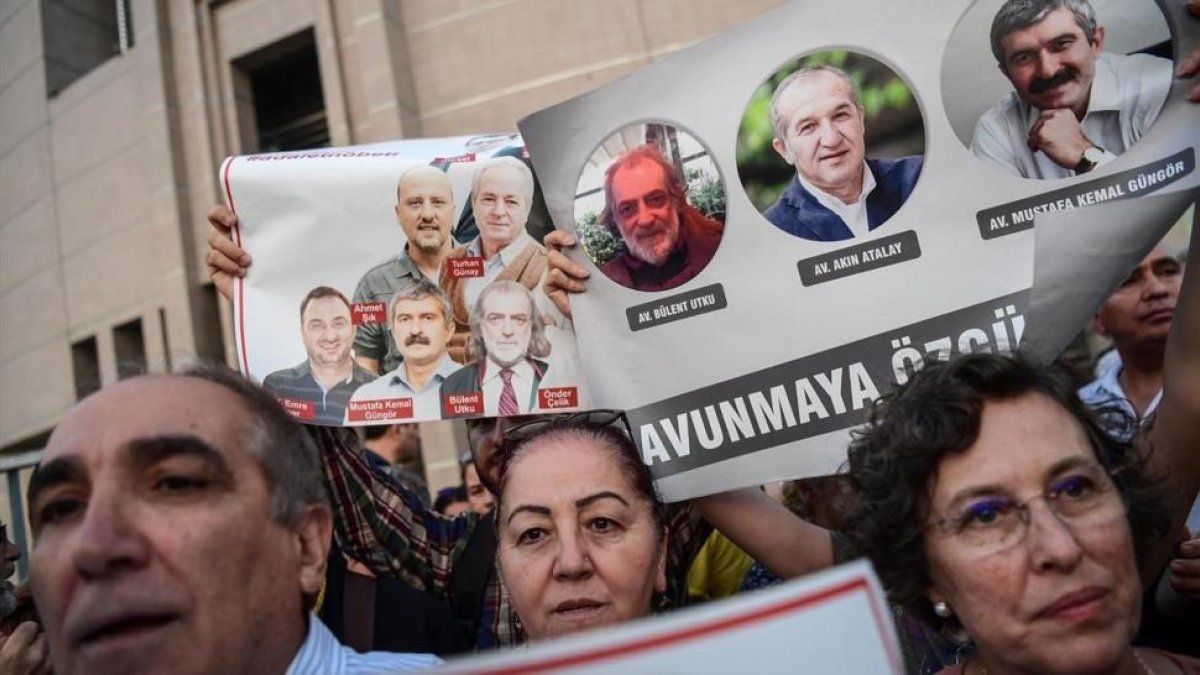 Un grupo de manifestantes muestran imágenes de periodistas del diario opositor Cumhuriyet, en una protesta en Estambul, el 28 de julio.-AFP / OZAN KOSE