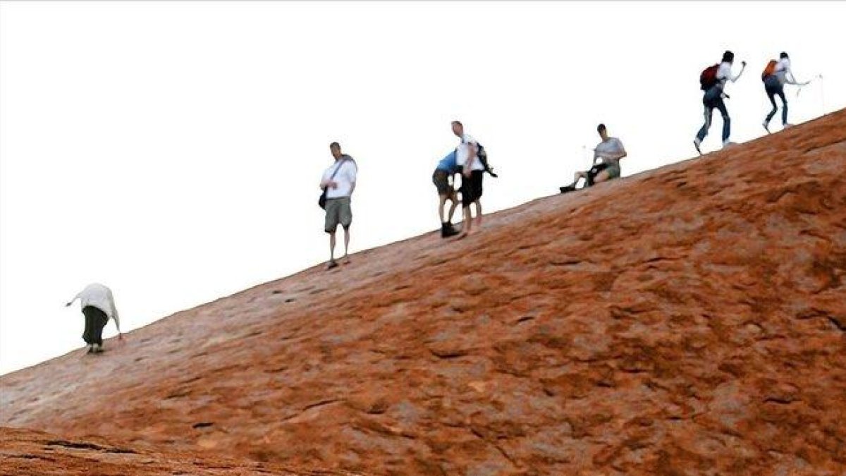 Turistas en el monte Uluru.-AFP
