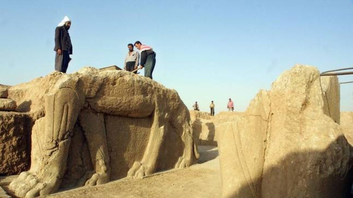 Trabajadores iraquís limpian las estatuas en el sitio arqueológico de Nimrod, en el 2001.-Foto: AFP / KARIM SAHIB