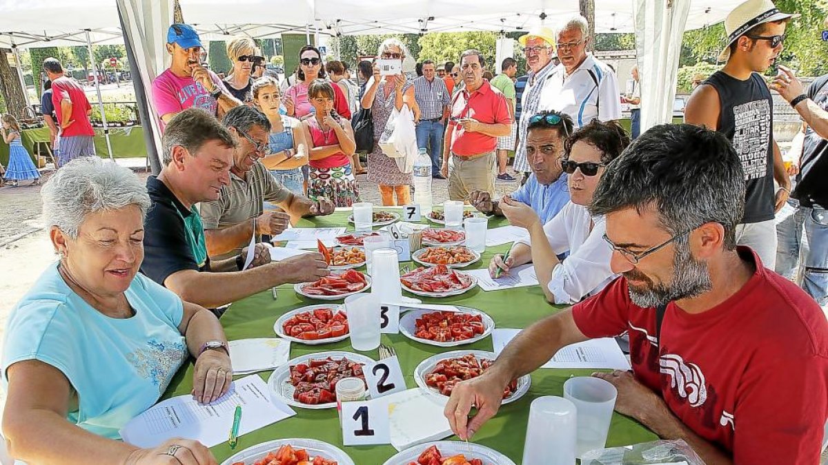 Varias personas observan los productos del mercado en la Feria del Tomate.-J. M. LOSTAU