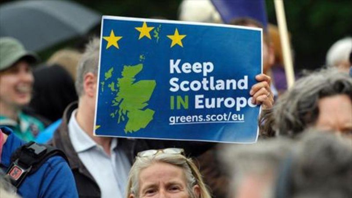 Una mujer sostiene una pancarta a favor de la permanencia de Escocia en la UE, ayer en Edimburgo.-AFP / ANDY BUCHANAN