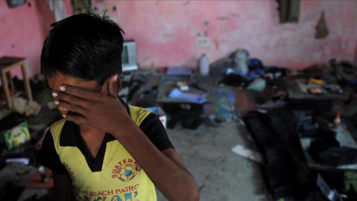 Un niño indio se cubre la cara en un suburbio de Delhi.-MANAN VATSYAYANA