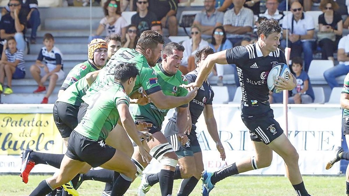 Tom Pearce corre con el oval ante la presencia de varios jugadores del Gernika.-J. M. LOSTAU